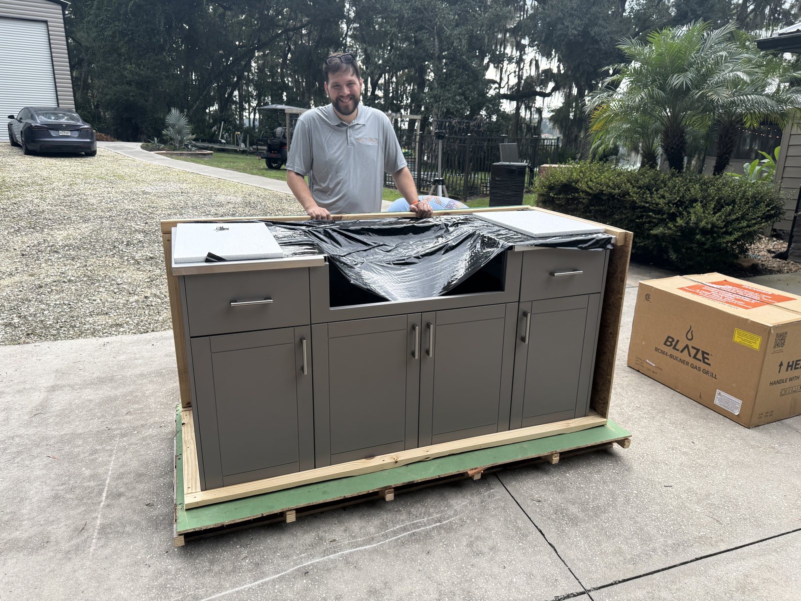 A six foot Fire Islands outdoor kitchen cabinet uncrated on its pallet in a customer driveway